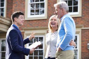 Realtor Showing Mature Couple Around House For Sale